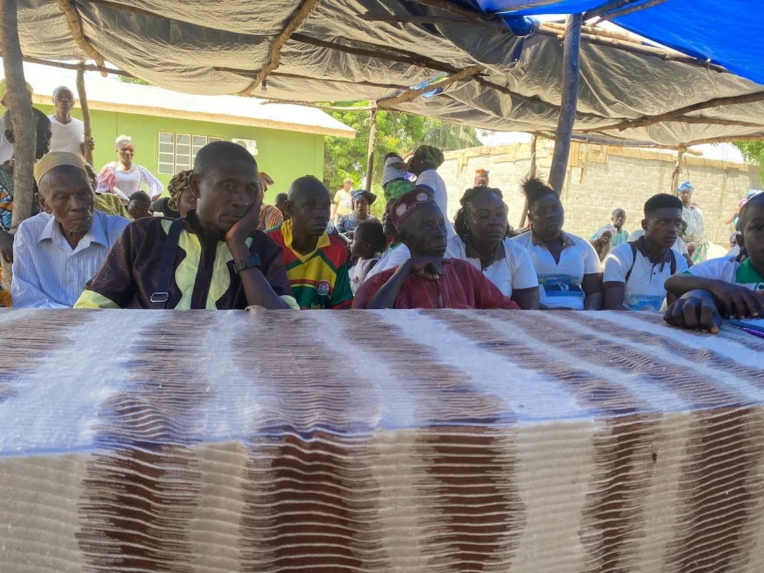Village elders and community leaders seated together at a community meeting